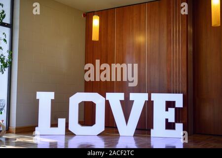 Illuminated Love sign in large letters at a wedding reception. Stock Photo