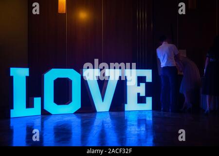 Illuminated Love sign in large letters at a wedding reception. Stock Photo