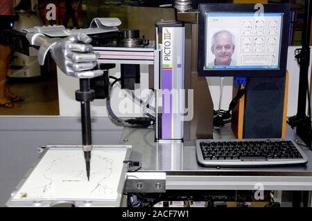 Picto painter robot. This painter robot captures an image of a human face using a CCD camera on its arm. The robot then picks up a pen and draws the h Stock Photo