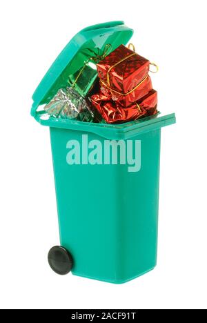 A green garbage bin filled with wasted wrapped gift boxes isolated on white background. Stock Photo