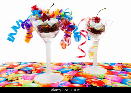 Homemade dark chocolate brownies topped with whipped cream and a maraschino cherry in martini glasses. Isolated on white background. Stock Photo