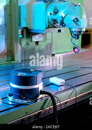 Calibrating a 3D measurement machine. Laser tracer calibrating an industrial coordinate measurement machine (CMM). CMMs are capable of accurate 3D mea Stock Photo