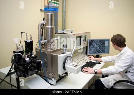 Scanning electron microscopy. Researcher operating a scanning electron microscope (SEM). Scanning electron microscopes use electrons to view objects a Stock Photo
