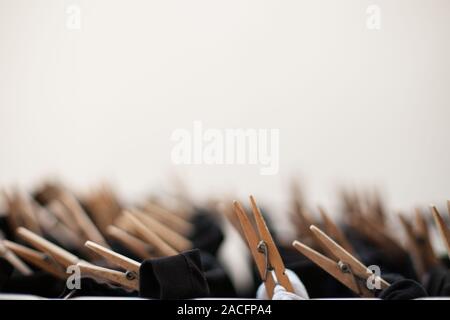 Wooden clothespins on the clothesline with black clothes hanging with unfocused background Stock Photo