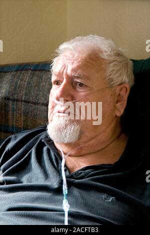 Elderly man with a oxygen tube. 67-year-old man with heart failure using an oxygen tube at home. Heart failure is a problem with the structure or func Stock Photo