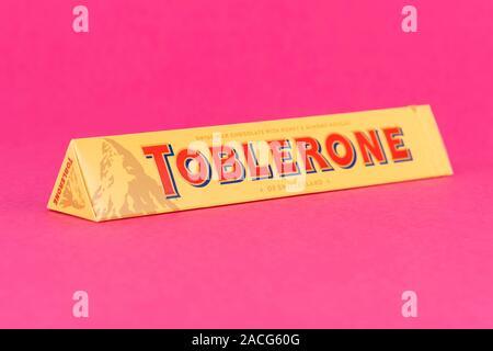 A Toblerone chocolate bar in a box shot on a pink background. Stock Photo