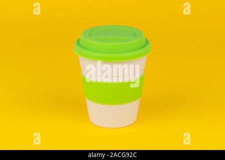 A reusable coffee cup shot on a yellow background. Stock Photo