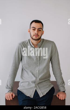 Portrait of a man sitting on the edge of table Stock Photo