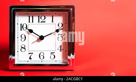 Holiday time, Black Friday Discount concept with metal silver clock on red color background. Shopping. Sale concept. Flat lay, top view, place for text. Stock Photo