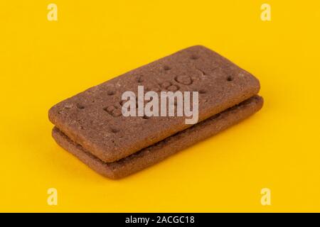 A chocolate Bourbon biscuit shot on a yellow background. Stock Photo