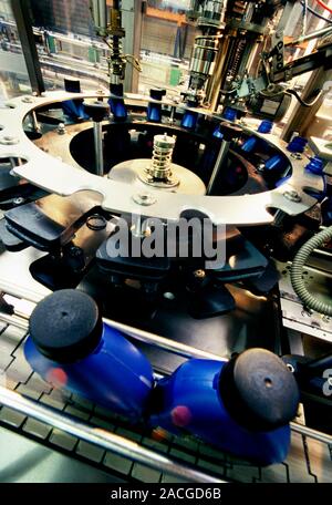 Factory production line. Close-up of bottles of oil being filled on the production line of a lubricants factory. Stock Photo
