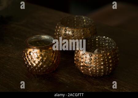 Three golden ornamental candle holders wiith copy space against dark background Stock Photo