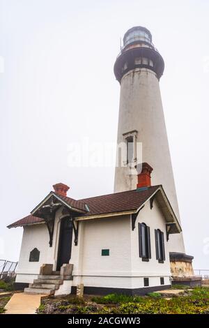 Historic Pigeon Point Lighthouse on the Pacific Ocean Coastline on a foggy day, California; Pigeon Point Lighthouse (built in 1871) and the land aroun Stock Photo