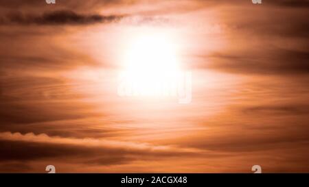 Sun shining through clouds at sunset Stock Photo