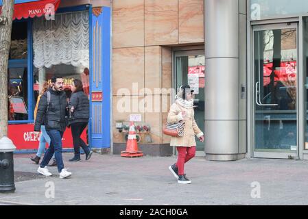 New York November 28 2019:  adult woman walking around crowd on New York City street-Image Stock Photo