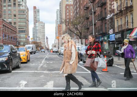 New York November 28 2019:  adult woman walking around crowd on New York City street-Image Stock Photo