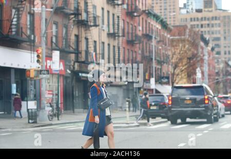 New York November 28 2019:  adult woman walking around crowd on New York City street-Image Stock Photo