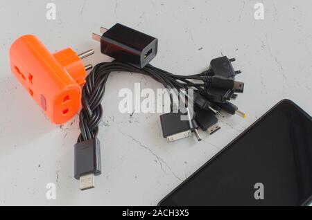 Universal USB plug with power supply for charging smartphones from various manufacturers. Stock Photo
