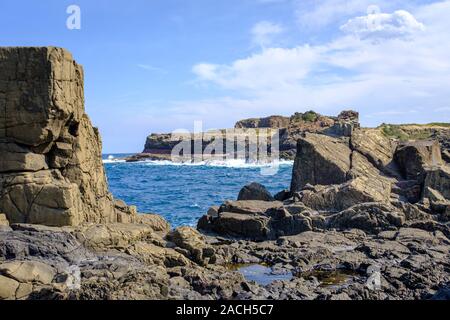 View over basalt rock formations and rock pools towards the sea at Bombo Headland quarry, New South Wales coast, Australia Stock Photo