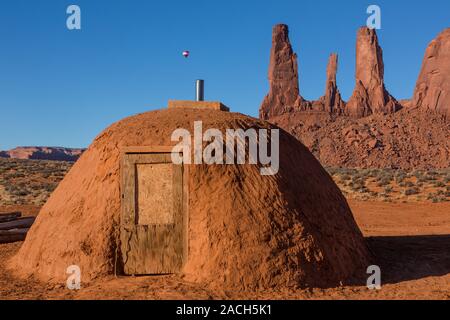 A hot air balloon flies by the Three Sisters in the Monument Valley Balloon Festival in the Monument Valley Navajo Tribal Park in Arizona, with a trad Stock Photo