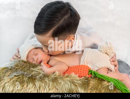 little boy kissing his newborn baby brother Stock Photo