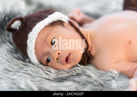 newborn baby in bear hat on a fur bed Stock Photo