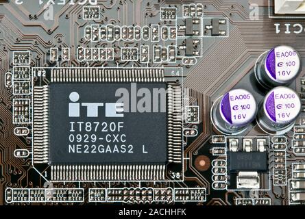 Computer microchip and capacitors. Super I/O (input/output) microchip (lower left) and capacitors (right) on an Asus (ASUSTeK Computer Incorporated) m Stock Photo