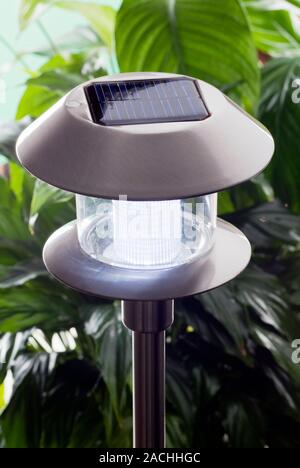 Solar-powered garden light. This garden light recharges a battery in daylight and switches on at night, sometimes wired up to a motion sensor. The pho Stock Photo