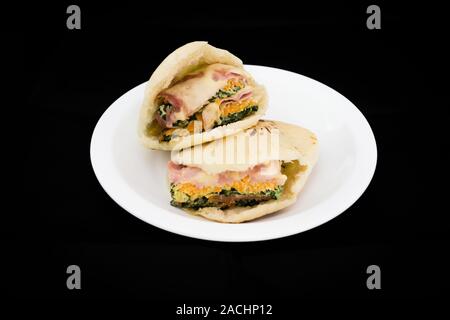 Pita pocket bread stuffed with cheese and sliced cooked ham, Malabar spinach and carrot frittata (fried beaten eggs), ready to eat Stock Photo