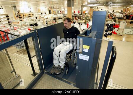 Wheelchair user. Man using a wheelchair lift in a shop. Stock Photo