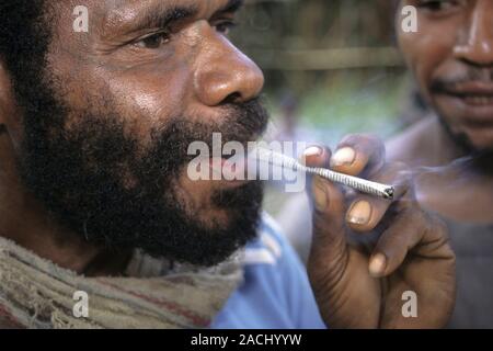local tobacco Local cigarette. Man smoking a crude, local cigarette, known as a 'spear  roll'. A local tobacco, known as 'Brus', has been rolled in newspaper and  the Stock Photo