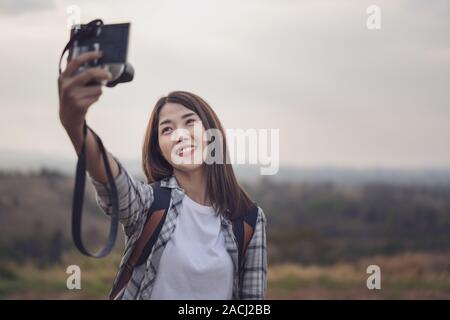 woman traveler using camera to making selfie in the mountain forest Stock Photo