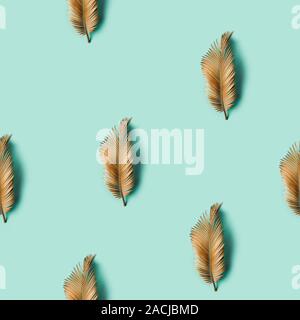 Seamless creative texture. Golden painted tropical leaf on pastel background. Stock Photo