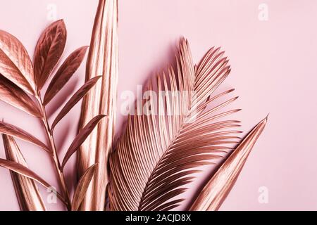 Natural Creative layout made of Painted pink metallic leaves on pink pastel background. Stock Photo