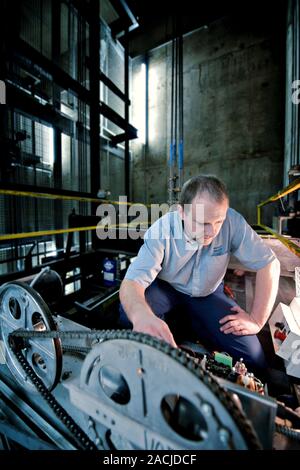 Lift engineer. Man working on a lift mechanism. Stock Photo