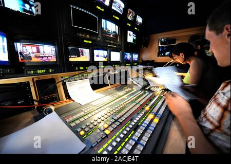 Television control room. Technicians operating control panels in a television control room. Stock Photo