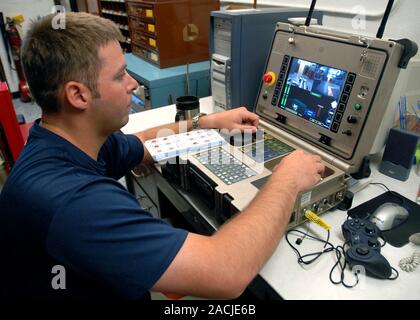PackBot explosives robot controls. US Navy explosive ordnance disposal (EOD) technician operating a PackBot robot being used to detect and handle expl Stock Photo