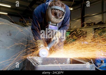 Metal working. Metalworker using an angle grinder in an engineering workshop. Stock Photo