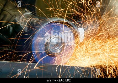 Metal working. Metalworker using an angle grinder in an engineering workshop. Stock Photo