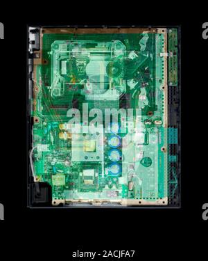 Games console. Coloured X-ray showing the internal components of a machine for playing video games. Stock Photo