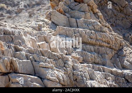 Geological textured cliff face showing years of sand and wind erosion in the desert of Ras al Khaimah, United Arab Emirates near Jebal Jais. Stock Photo