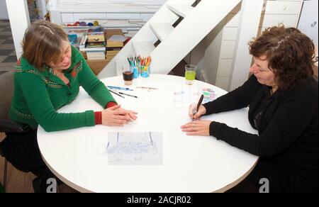 Drawing therapy. Therapist taking notes during a drawing therapy session. Stock Photo