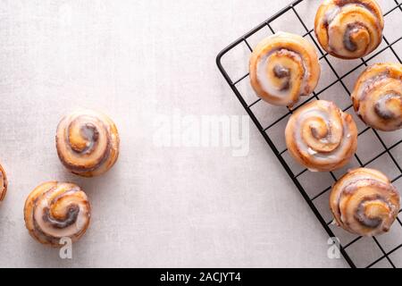 Homemade baked cinnamon rolls on cooling on cooling rack Stock Photo