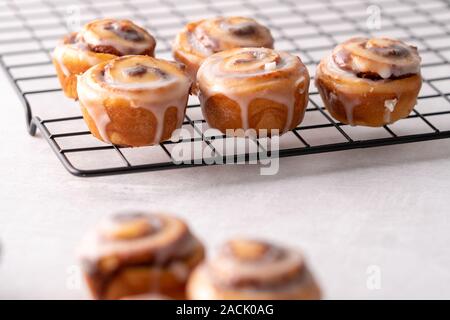 Homemade baked cinnamon rolls on cooling on cooling rack Stock Photo