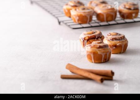 Homemade baked cinnamon rolls on cooling on cooling rack Stock Photo