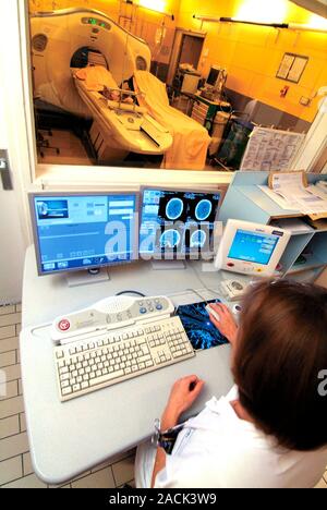 MRI scan. Radiographer operating an MRI (magnetic resonance imaging) scanner in a hospital. Photographed in Nice, France. Stock Photo