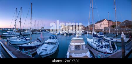 Boats moored in Victoria Dock, Caernarfon, North Wales at sunset Stock Photo