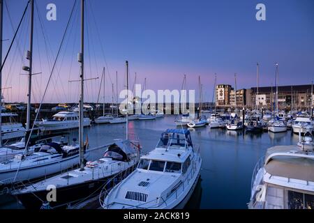 Boats moored in Victoria Dock, Caernarfon, North Wales at sunset Stock Photo