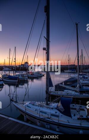 Boats moored in Victoria Dock, Caernarfon, North Wales at dusk Stock Photo