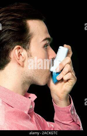 Asthma inhaler. Patient using an asthma inhaler containing Salamol (Salbutamol). Asthma is a condition in which the small airways (bronchioles) in the Stock Photo